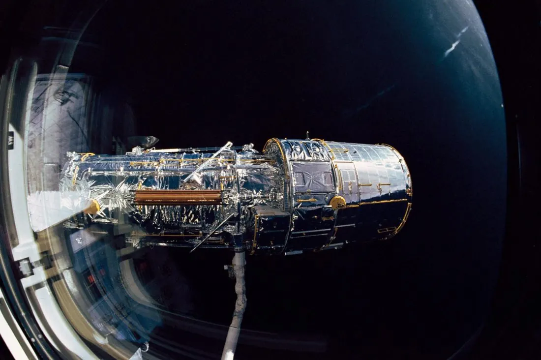 The Hubble Space Telescope held by the Space Shuttle's robotic arm during its 1990 deployment